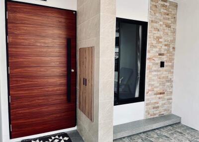 Elegant home entrance with wooden door and decorative tile wall