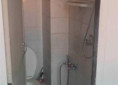 Compact tiled bathroom with toilet and shower
