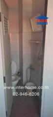 Compact tiled bathroom with toilet and shower