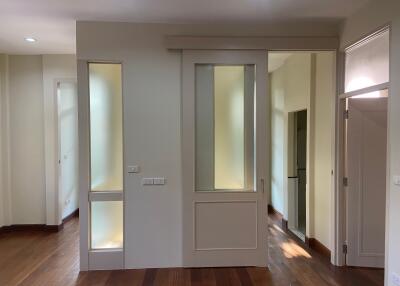 Bright and modern hallway with wooden floors and frosted glass doors