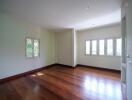 Spacious living room with wooden flooring and ample natural light