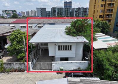 Two-story house with a metal roof and outdoor greenery