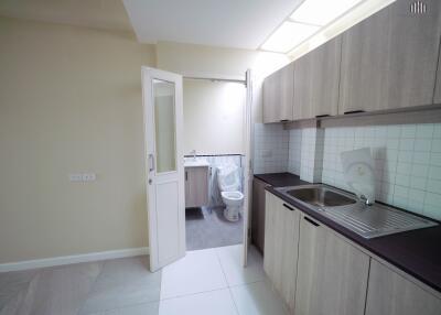 Modern kitchen view including sink area and partially visible bathroom