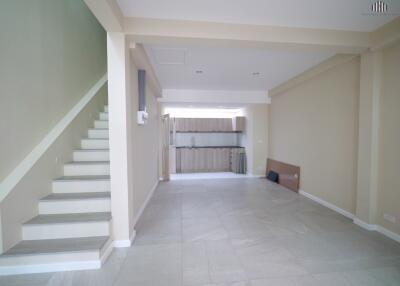 Spacious open-plan living area with stairs and kitchen view