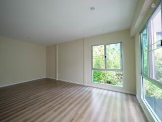 Spacious living room with large windows and wooden flooring