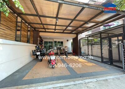 Modern carport attached to a residential home with transparent roof and a collection of motorcycles
