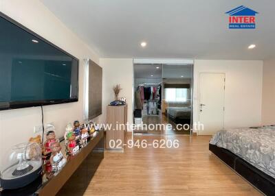 Spacious bedroom with modern television and ample storage
