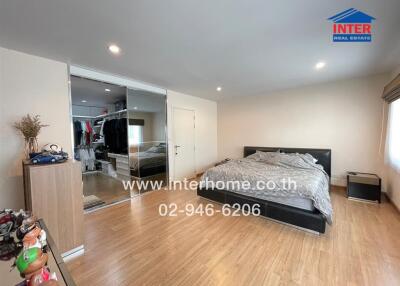Spacious bedroom with large mirrored wardrobe and hardwood flooring