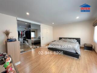 Spacious bedroom with large mirrored wardrobe and hardwood flooring