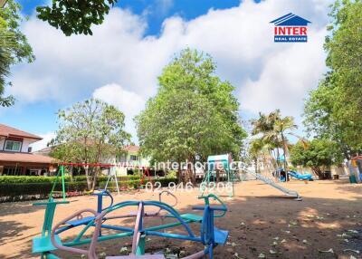 Spacious outdoor playground with lush greenery and colorful play equipment