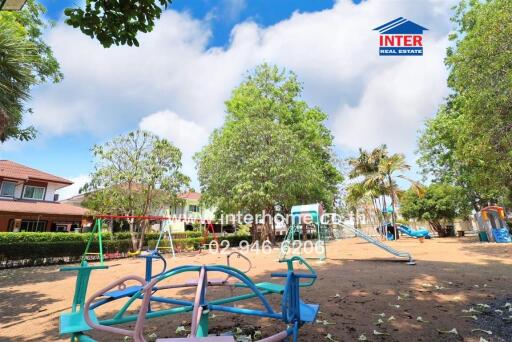 Spacious outdoor playground with lush greenery and colorful play equipment