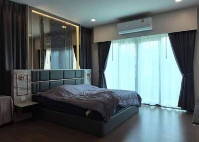 Spacious modern bedroom with large bed, air conditioning, and ample natural light
