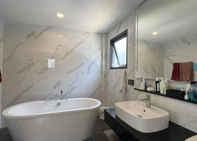 Modern bathroom with freestanding tub and large mirror