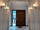Elegant hallway with wooden door and stylish wall sconces