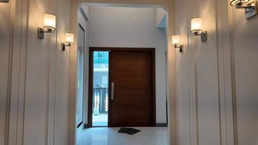 Elegant hallway with wooden door and stylish wall sconces