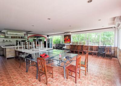 Spacious kitchen and dining area with large windows and lush greenery outside