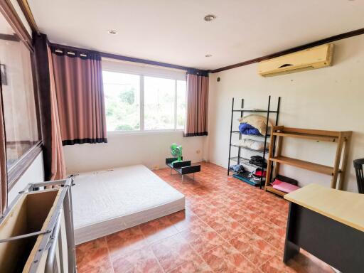 Spacious bedroom with large windows and air conditioning