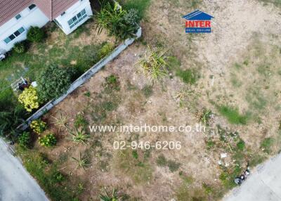 Aerial view of residential property with surrounding landscaping and real estate signage