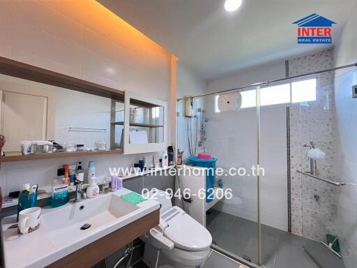 Modern bathroom interior with well-lit vanity area and glass shower enclosure