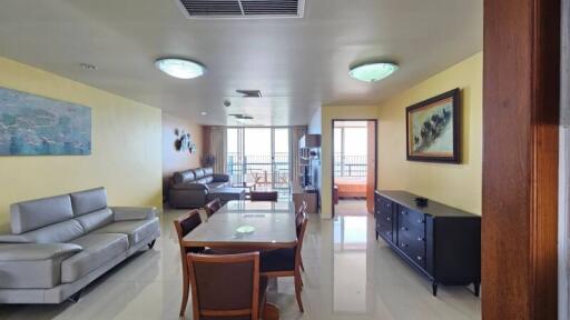 Spacious and well-lit living room with dining area and balcony access