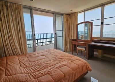 Spacious bedroom with ocean view, large windows, and modern furniture