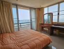 Spacious bedroom with ocean view, large windows, and modern furniture