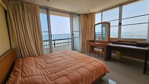 Spacious bedroom with ocean view, large windows, and modern furniture