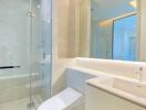 Modern bathroom with glass shower enclosure and white vanity