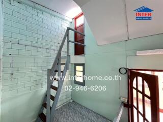 Brightly lit staircase area with mint-colored walls and a metallic stairway