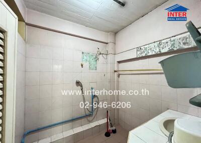 Compact tiled bathroom with basic amenities