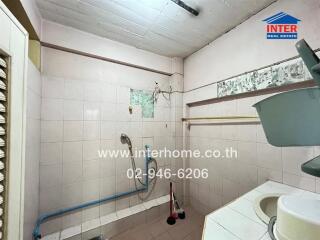 Compact tiled bathroom with basic amenities