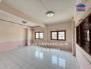 Spacious unfurnished living room with large windows and tiled flooring