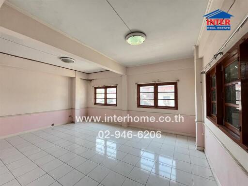 Spacious unfurnished living room with large windows and tiled flooring