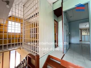 Spacious interior view of a building with security grills and sliding doors leading to various rooms