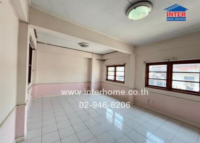 Spacious living room with large windows and tiled flooring