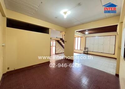 Spacious living room with staircase and ceramic tile flooring
