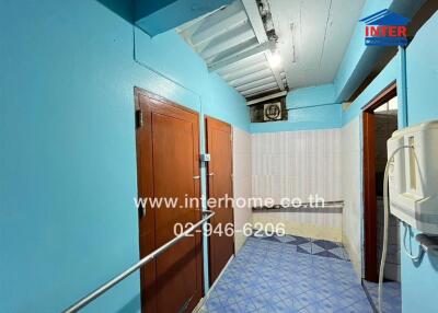 Brightly colored hallway in building featuring wooden doors and tiled floor