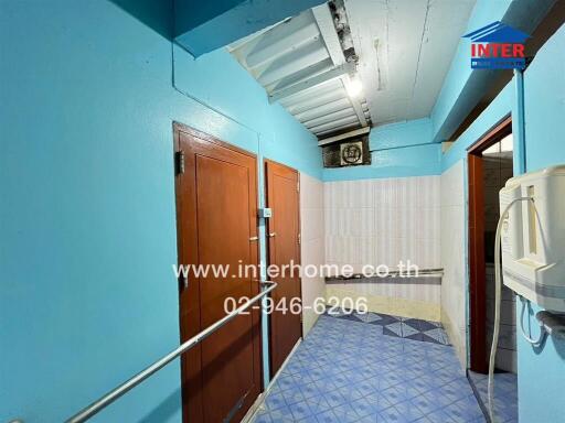 Brightly colored hallway in building featuring wooden doors and tiled floor