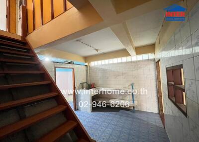 Spacious multi-functional living area with staircase and tile flooring