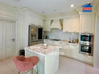 Elegant white themed kitchen with modern appliances and a stylish breakfast bar