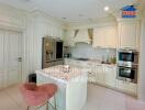 Elegant white themed kitchen with modern appliances and a stylish breakfast bar