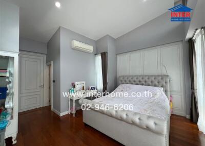 Spacious and elegantly designed bedroom with wooden flooring and modern amenities