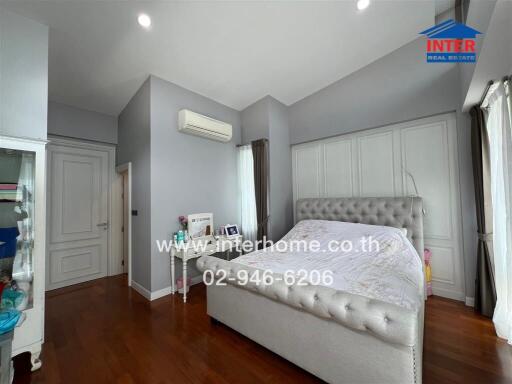 Spacious and elegantly designed bedroom with wooden flooring and modern amenities