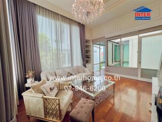 Elegant living room in a modern apartment with chandelier and balcony view