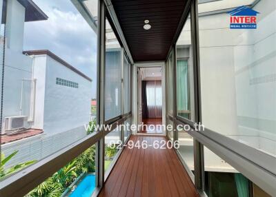 Spacious balcony with wooden flooring and glass railing