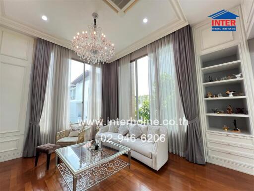 Elegant living room with chandelier, high ceiling, and large windows