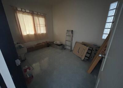 Spacious and partially furnished bedroom with natural light