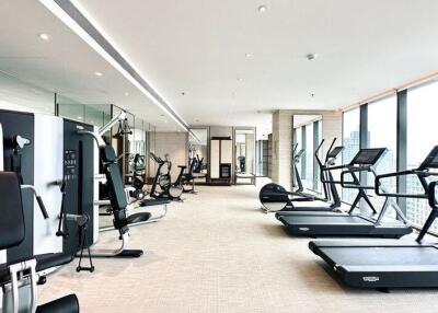 Modern gym within a high-rise building featuring cardio and strength training equipment