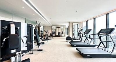 Modern gym within a high-rise building featuring cardio and strength training equipment