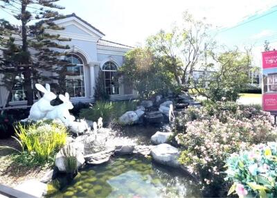 Elegant house exterior with decorative pond and statues